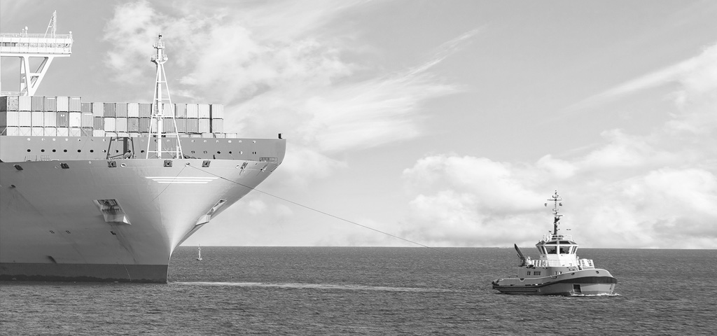 Frachtschiff wird von Schlepper gezogen | © GettyImages / nightman1965 Frachtschiff wird von Schlepper gezogen